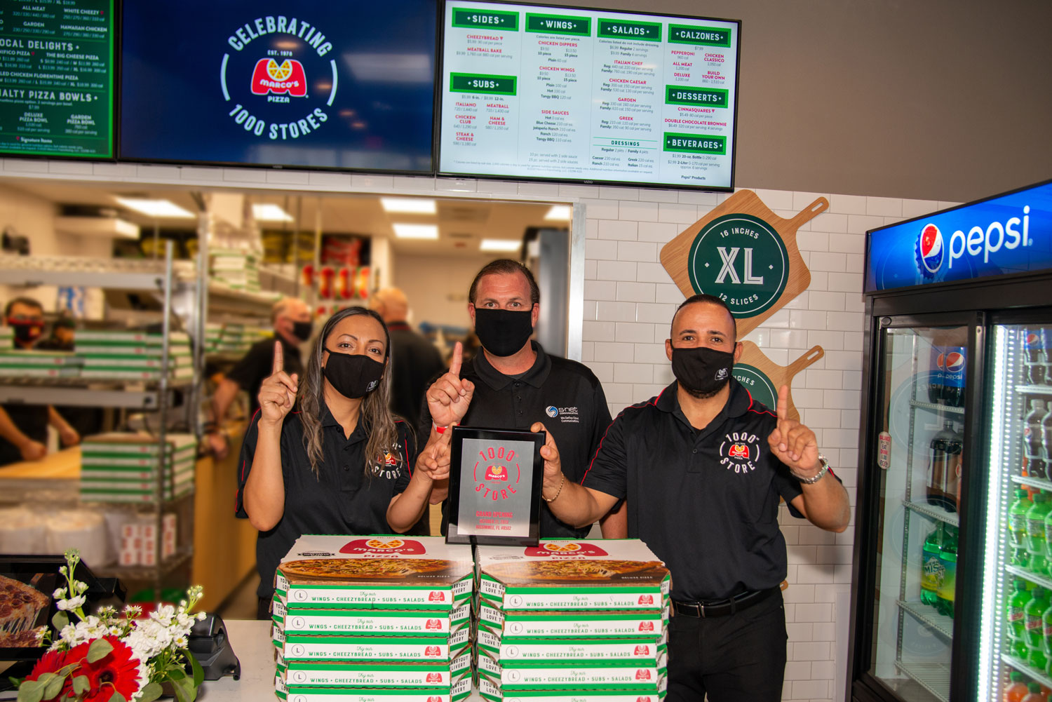 S-NET Communications Strategic Alliance Manager Mike Muar with the owners of the 1000th Marco's Pizza store
